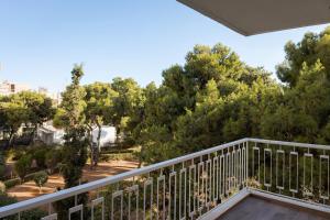 a balcony with a view of trees at Vouliagmeni Olivomare Suite in Athens