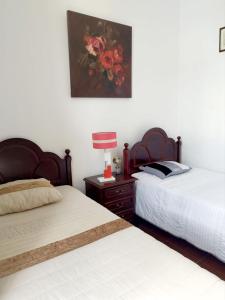 a bedroom with two beds and a lamp on a night stand at Recanto do Capucho in Conceição