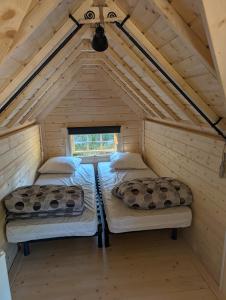 two beds in a room in a wooden house at Camping de Graçay in Graçay