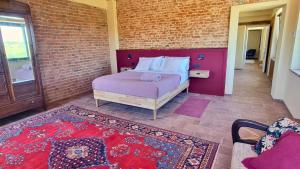 a bedroom with a bed and a brick wall at Ca' Sinoira in Nizza Monferrato