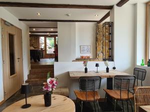 a dining room with a table and chairs and a staircase at Le Vernay en Savoie - Petit Hôtel Nature in Saint-Maurice-de-Rotherens