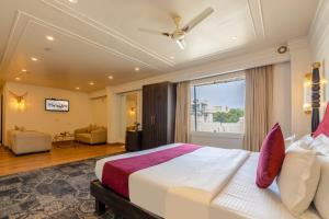 a bedroom with a large bed and a large window at The Saga Hotel Green Park in New Delhi