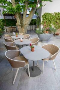 a row of tables and chairs in a courtyard at Hôtel Boutique Cézanne centre Aix-en-Provence in Aix-en-Provence