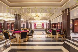 a banquet hall with tables and chairs and chandeliers at The Saga Hotel Green Park in New Delhi