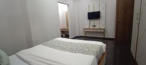 a bedroom with a bed and a television in it at Savanna Farm in Nagpur