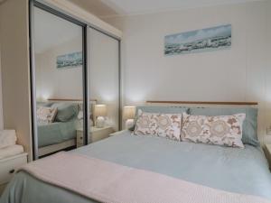 a bedroom with a large bed and a mirror at Hazelwood 3 in Lyme Regis +32 photos
