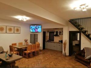 a living room with a dining table and a kitchen at Casa Om Bun in Beclean