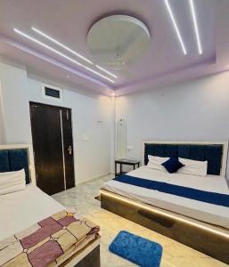 a bedroom with two beds and a mirror on the ceiling at Shri Homestay 800m from kashi vishwanath in Varanasi