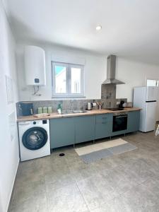 a kitchen with a sink and a washing machine at The Nook, Lourinha in Lourinhã