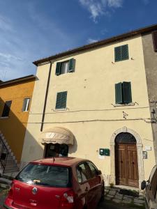 a red car parked in front of a building at La Casetta dei Mauri in Saturnia