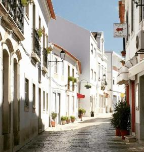 a cobblestone street in a town with white buildings at The Nook, Lourinha in Lourinhã