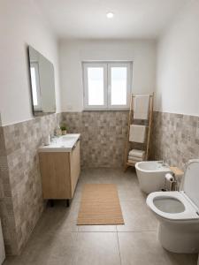 a bathroom with a toilet and a sink and a toilet istg at The Nook, Lourinha in Lourinhã