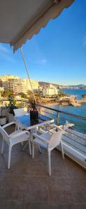 a table and chairs on a balcony with a view of the water at Βeachfront Luxury Apartments SARANDE in Sarandë