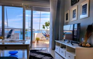 a living room with a desk and a television at Βeachfront Luxury Apartments SARANDE in Sarandë