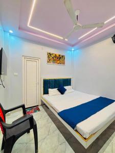 a bedroom with a bed and a chair in it at Shri Homestay 800m from kashi vishwanath in Varanasi