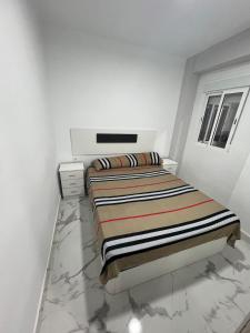 a white bedroom with a bed and a marble floor at Gandía Jacuzzi Suites in Gandía +4 photos