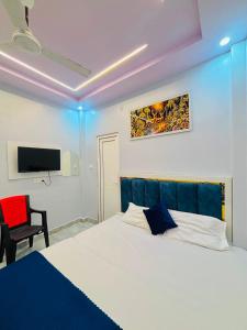 a bedroom with a white bed and a tv at Shri Homestay 800m from kashi vishwanath in Varanasi