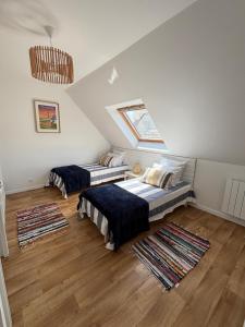 a attic room with two beds and two rugs at Résidence de la Presqu'île in Plougonvelin