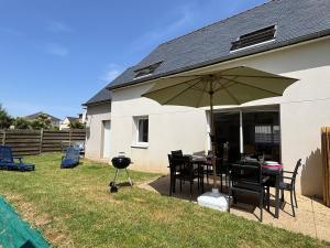 a patio with a grill and a table with an umbrella at Résidence de la Presqu'île in Plougonvelin +21 photos