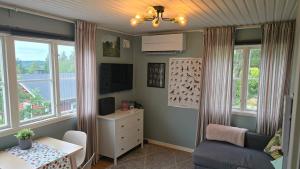 a living room with a table and a chair and windows at Örnen' in Undenäs