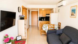 a living room and kitchen with a couch and a table at Salou Beach Apartment with private Pool in Salou