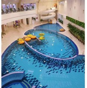 a large swimming pool in a large building at Casa Om Bun in Beclean