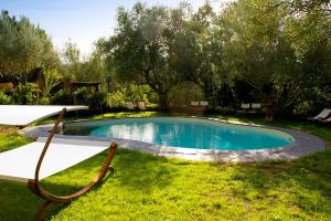 a swimming pool in the grass with two chairs around it at La Corte di Maria in Piccilli +60 photos