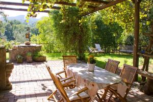 a patio with a table and chairs and a pergola at La Corte di Maria in Piccilli