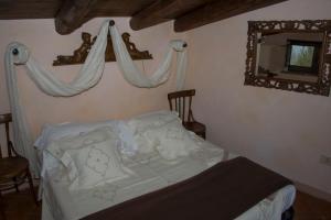a bedroom with a bed with a mirror on the wall at La Corte di Maria in Piccilli