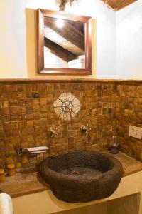 a bathroom with a large stone sink with a mirror at La Corte di Maria in Piccilli