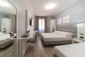 a hotel room with two beds and a desk at Hotel University in Bologna +37 photos