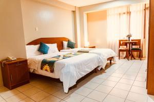 a bedroom with a bed and a table and a window at Hotel INTERnazionale in Ayacucho