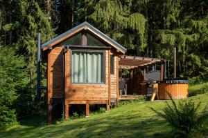 a wooden cabin on a grassy hill in a field at Glamping Walden in Nový Hrozenkov