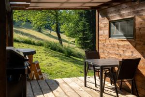 a patio with a table and chairs on a deck at Glamping Walden in Nový Hrozenkov +3 photos