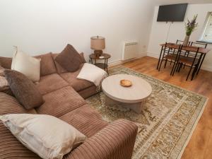a living room with a couch and a table at Gews Farm Lodge in Penzance