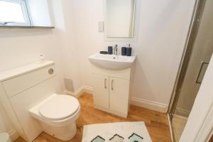 a white bathroom with a toilet and a sink at Gews Farm Lodge in Penzance +12 photos