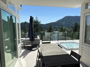 a patio with a table and a swimming pool on a house at Bowen Island Ocean Retreat in Bowen Island