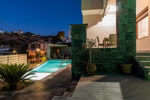 a villa with a swimming pool at night at Sea Front Panorama Villa Private Pool in Agia Pelagia