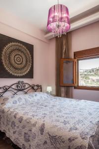 a pink bedroom with a bed and a pink chandelier at Sea Front Panorama Villa Private Pool in Agia Pelagia +40 photos