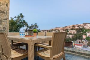 a table and chairs on a balcony with a view at Sea Front Panorama Villa Private Pool in Agia Pelagia