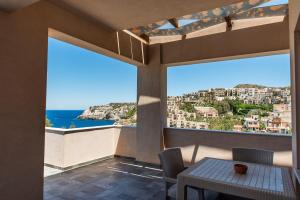 a balcony with a table and chairs and a view of the ocean at Sea Front Panorama Villa Private Pool in Agia Pelagia
