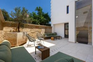 a patio with a couch and chairs and a fireplace at Domus Sagari in Presicce
