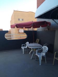 a patio with a table and chairs and an umbrella at Grand Studio bien équipé in Oujda