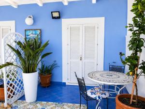 a blue room with a table and chairs and plants at Casa Simonetta il Roseto in Ponza