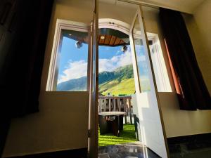 an open door with a view of a mountain view at Arkay Sonamarg in Sonāmarg