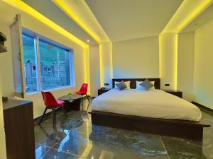 a bedroom with a bed and two red chairs at Arkay Sonamarg in Sonāmarg