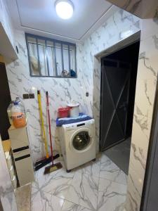 a kitchen with a washing machine in a room at Grand Studio bien équipé in Oujda