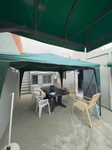a patio with a table and chairs under a green tent at Grand Studio bien équipé in Oujda