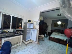 a kitchen with a refrigerator and a bed in a room at Grand Studio bien équipé in Oujda +5 photos