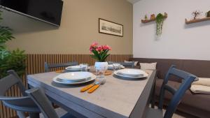 a table with plates and utensils and flowers on it at Appartamento Squarà - con Vista Cascata, vicino Verona in Montorio Veronese